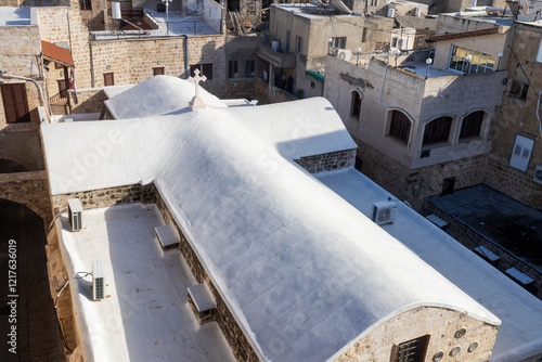 Acre, Israel, January 20, 2025. A glimpse of the ancient town and the Greek Orthodox Cathedral of St. George. The church roof is crafted as a white cross. photo