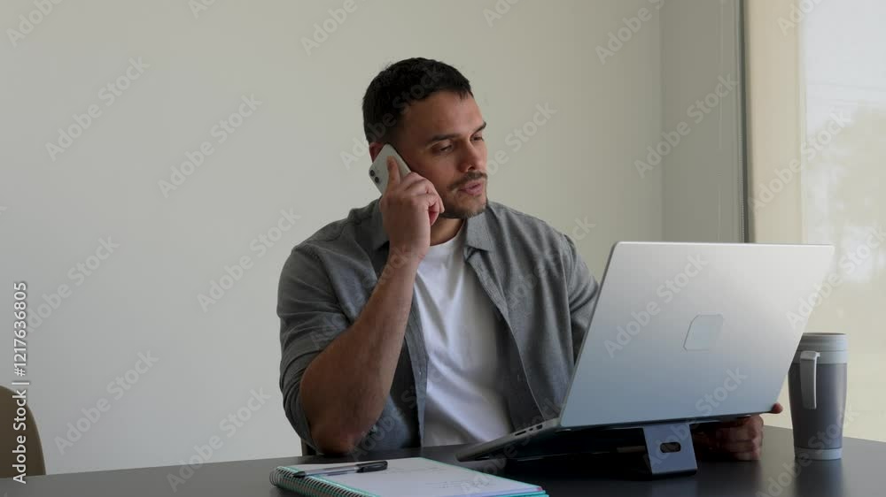 Young businessman typing on a laptop in a bright office Young businessman typing on a laptop in a bright office