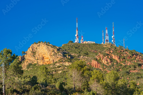 Communication towers on top of a mountain against the blue Sky, Bartolo, Castellón, Spain photo