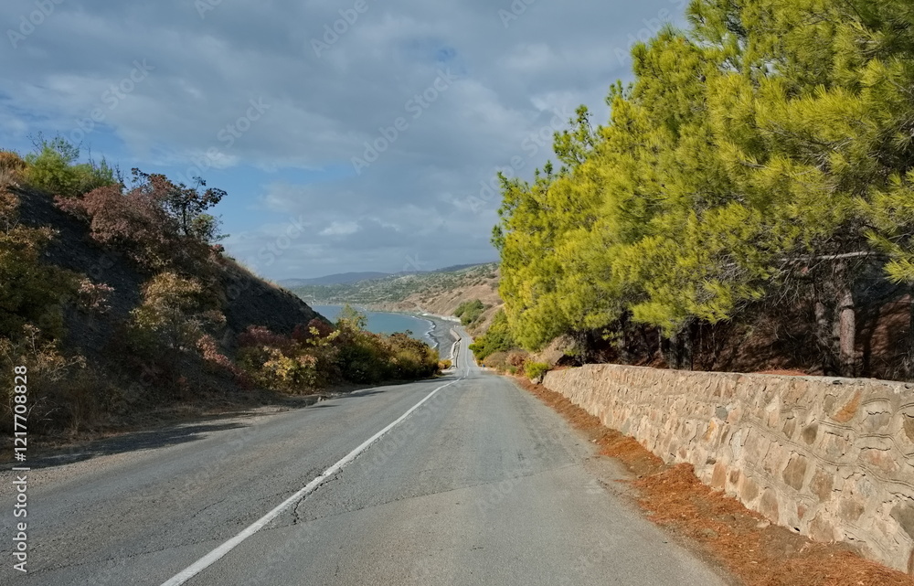 Fototapeta premium Russia, Republic of Crimea. View of the winding paved road along the Black Sea coast near the town of Sudak surrounded by picturesque mountains.