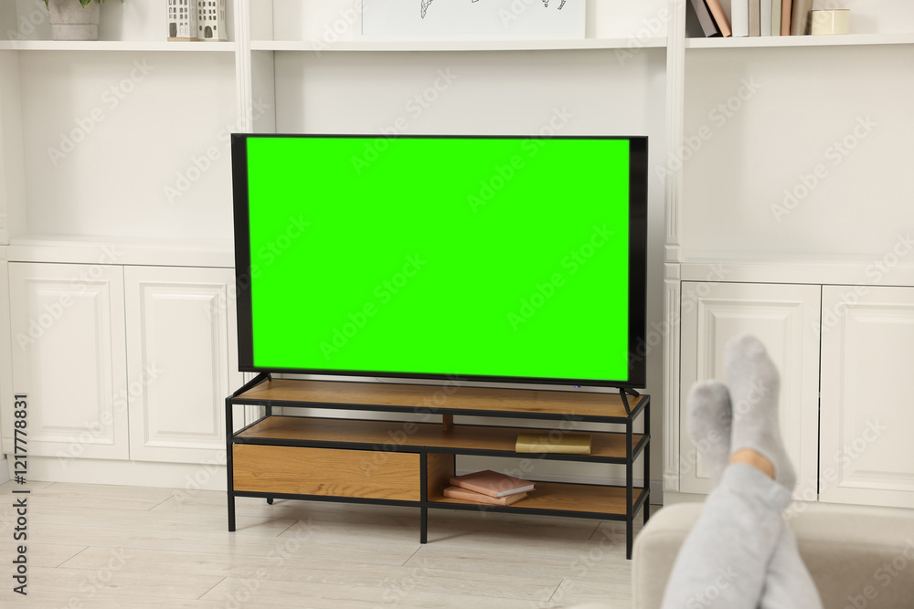 Man watching TV on sofa at home, closeup