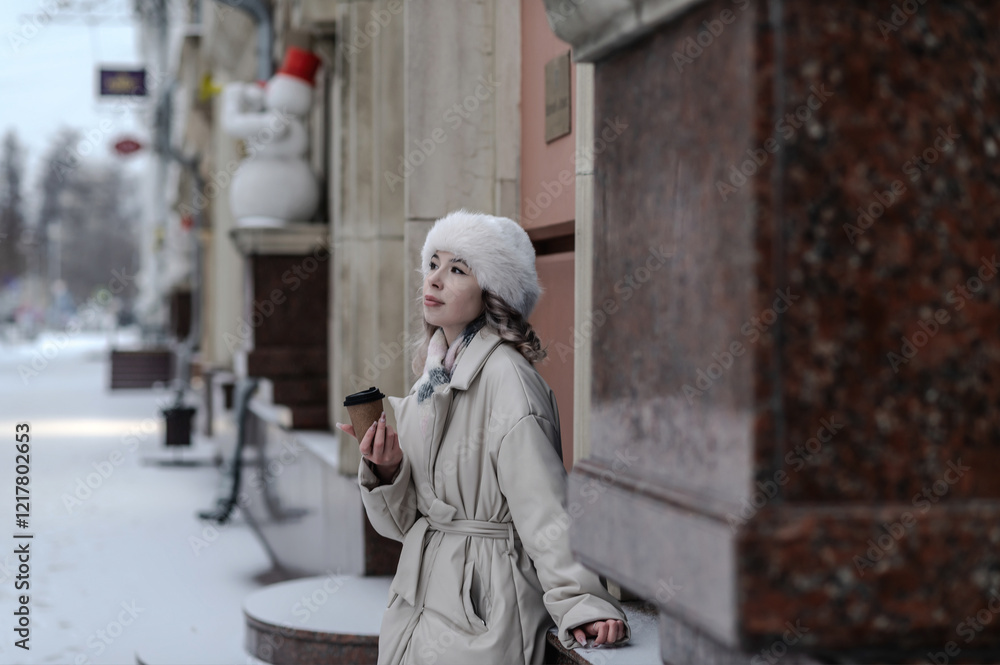 Fototapeta premium A girl walks through a city decorated for Christmas in winter