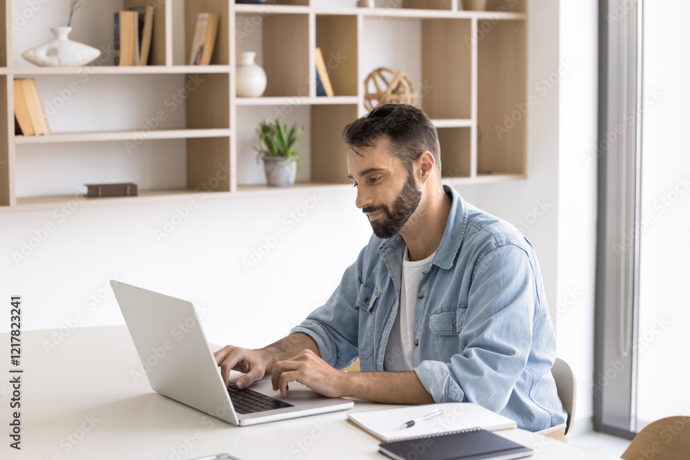 Young Hispanic businessman working online on project using laptop, answers on e-mail, lead business chat with client, managing meetings, editing documents, check correspondence sit at modern workplace Young Hispanic businessman working online on project using laptop, answers on e-mail, lead business chat with client, managing meetings, editing documents, check correspondence sit at modern workplace