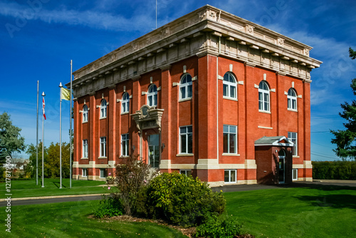 A large brick building with a green lawn in front of it