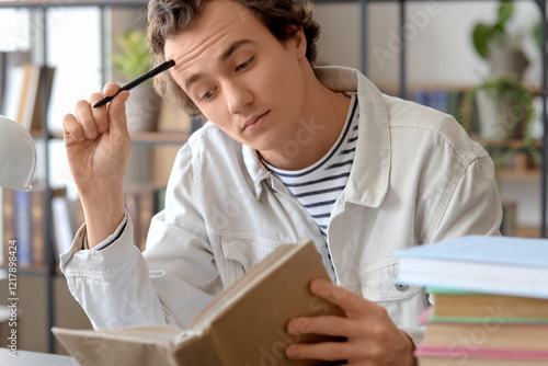 Young man reading book at t...