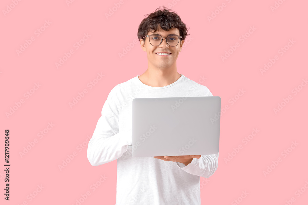 Male programmer with laptop on pink background Male programmer with laptop on pink background