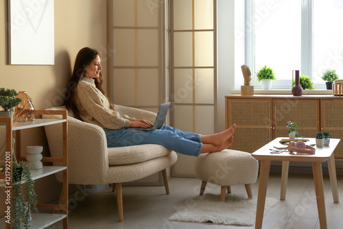 Young woman using laptop on...