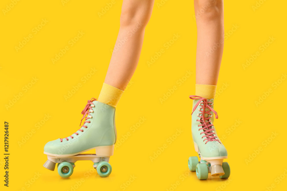 Legs of woman in roller skates on yellow background Legs of woman in roller skates on yellow background