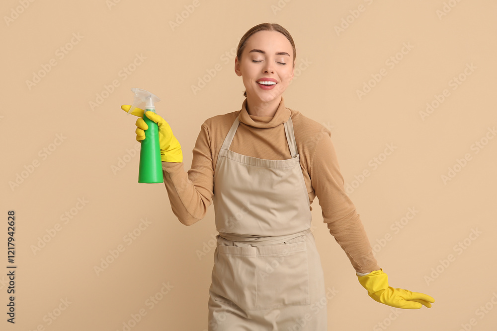 Young woman with spray bottle on beige background Young woman with spray bottle on beige background