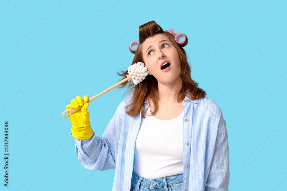 Shocked young woman with hair curlers and toilet brush on blue background Shocked young woman with hair curlers and toilet brush on blue background