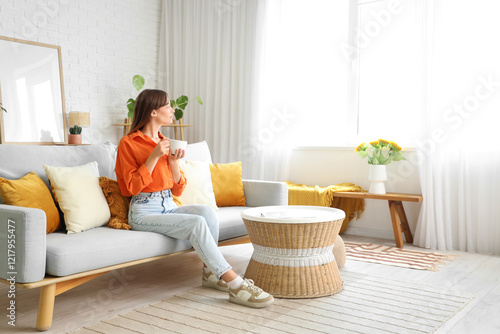 Pretty young woman drinking tea at home
