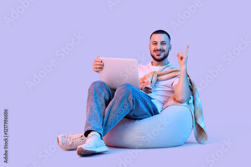 Young man with laptop point...