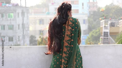 Wallpaper Mural A Bengali woman, wearing a beautiful green block-printed salwar kameez, stands alone on a rooftop in the afternoon. The air moves her long black hair and clothes. She looks outside, lost in thought. Torontodigital.ca