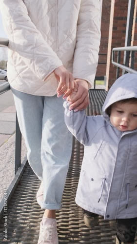 The mother and the small child are leaving the house for a walk. Vertical video