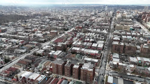 Horizontal drone circular-tracking shot over Troy Ave, Brooklyn, showcasing New York’s dynamic rooftops, vibrant streets, and urban charm from a smooth aerial rotation. photo