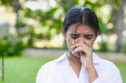 Allergic sick South Asian or Indian woman having runny nose, nose stiffness, stiff nose with snot, nasal mucus due to cold or flu, air dust pollution allergy, health care and allergy concept image photo