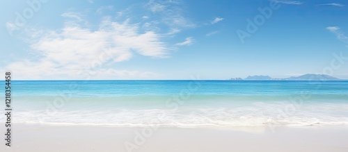 Wallpaper Mural Panoramic beach view at daylight with turquoise ocean gently lapping at sandy shore under a clear blue sky and soft white clouds in the distance Torontodigital.ca
