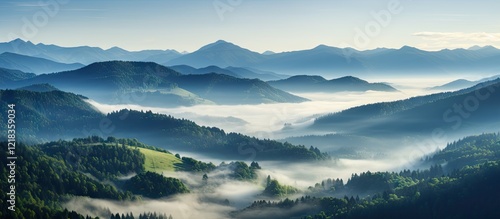 Wallpaper Mural Mountain landscape with rolling hills and mist at sunrise; soft blue and green tones; layered mountains and valleys create depth and tranquility. Torontodigital.ca