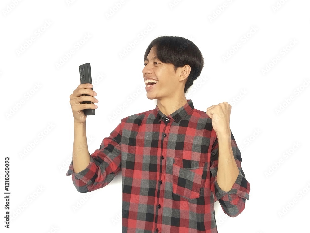 Young Asian man showing happy gesture while looking at his cell phone, happy while looking at cell phone Young Asian man showing happy gesture while looking at his cell phone, happy while looking at cell phone
