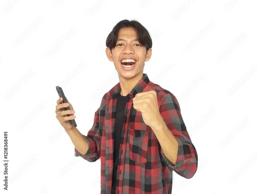 Young Asian man looking at camera while holding mobile phone showing enthusiastic expression