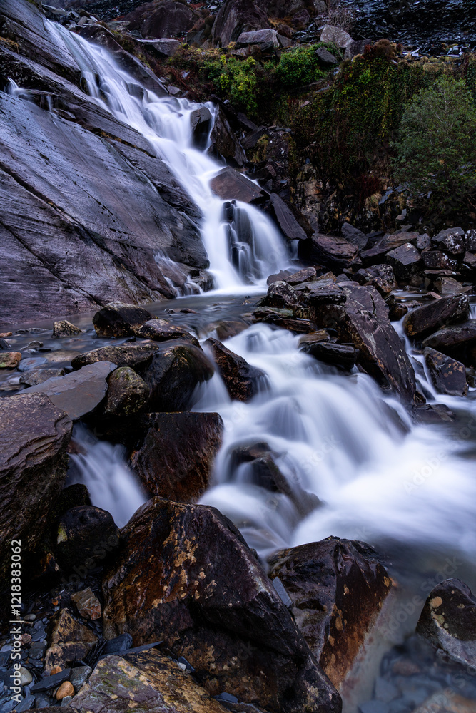 Waterfall flowing over rocks in mountainous area Waterfall flowing over rocks in mountainous area