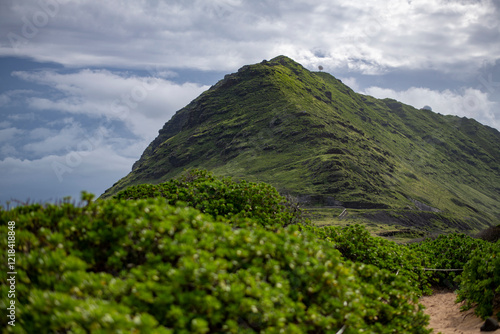 View of lush green mountain with satellite dish on Ka'Ena Point photo