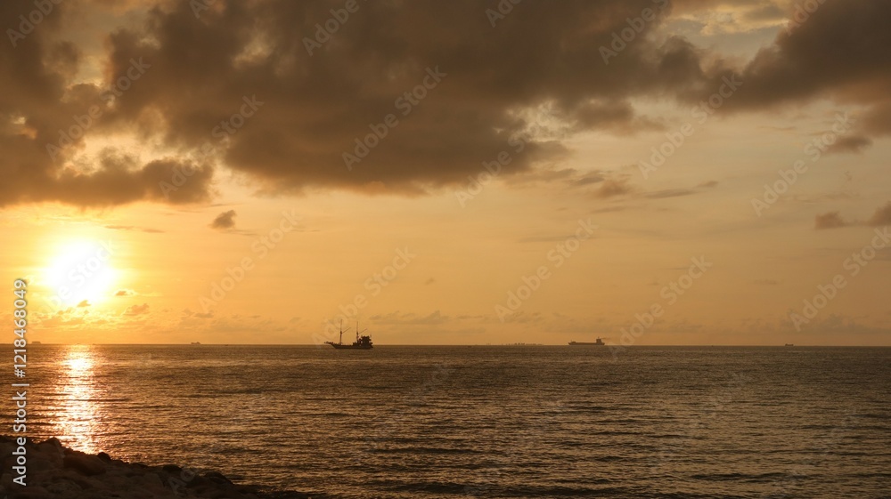 Obraz premium Low orange sunset in dramatic clouds over ocean in Indonesia