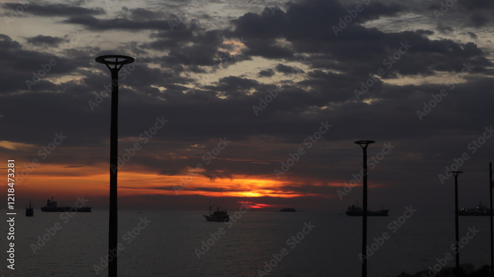 Low orange sunset in dramatic clouds over ocean in Indonesia Low orange sunset in dramatic clouds over ocean in Indonesia