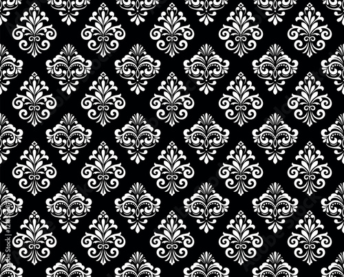 Wallpaper in the style of Baroque. Seamless vector background. White and black floral ornament. Graphic pattern for fabric, wallpaper, packaging. Ornate Damask flower ornament.