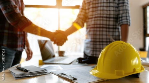 Construction handshake deal office sunlit blueprints