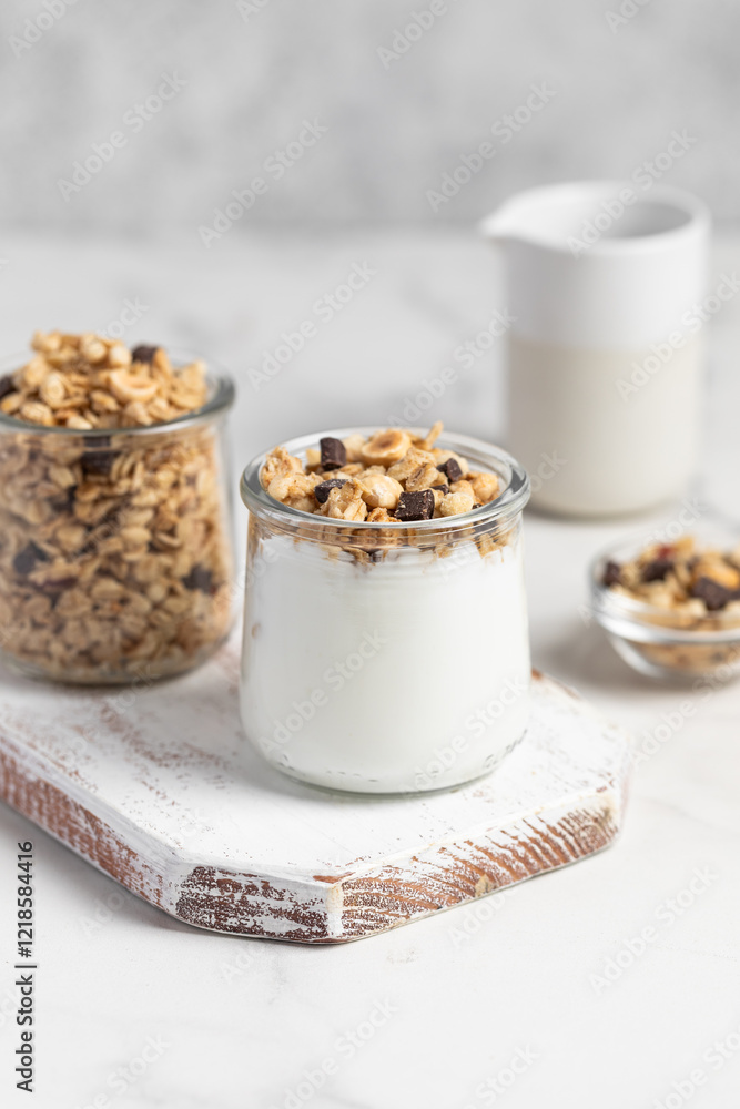 granola with chocolate, yogurt with granola in a glass jar granola with chocolate, yogurt with granola in a glass jar