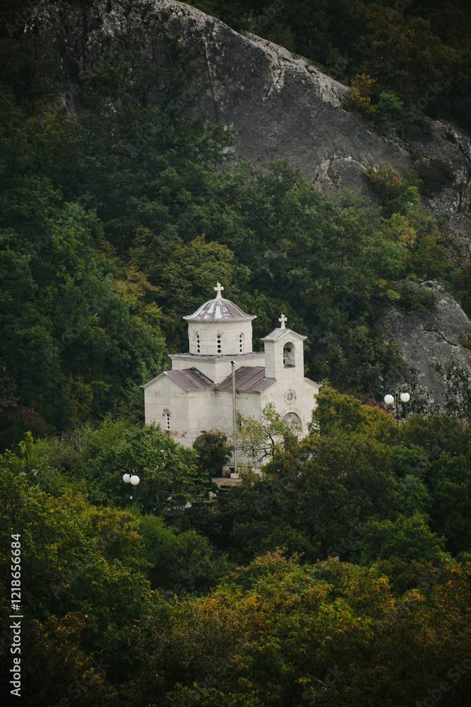 A small old stone Christian church on a serpentine in the mountains on the way to the most famous and popular place among tourists - Ostrog Monastery. Montenegro country. A small old stone Christian church on a serpentine in the mountains on the way to the most famous and popular place among tourists - Ostrog Monastery. Montenegro country.