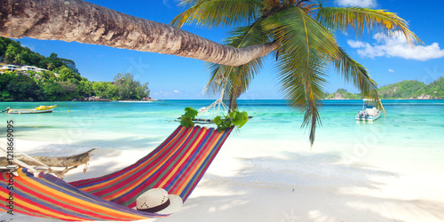 Fototapeta Naklejka Na Ścianę i Meble -  amazing beach with red hammock on a palm tree against turquoise sea