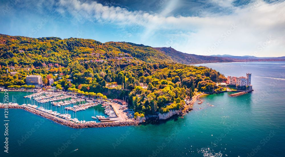 Fototapeta premium Wonderful summer view from flying drone of Miramare Castle. Nice morning seascape of Adriatic sea with Grignano port. Spectacular outdoor scene of Italy, Europe. Traveling concept background.