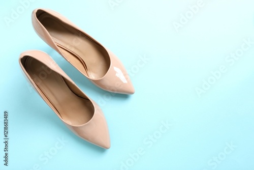 Stylish classic women's beige high heel shoes on color background. Top view, flat lay