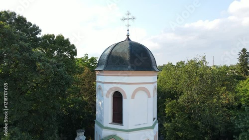 Bell tower of a historic church among trees. Concept of a religious place for worshiping God. photo