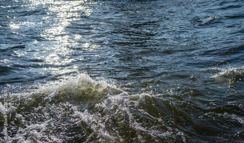 Water surface with ripples and sunlight reflections