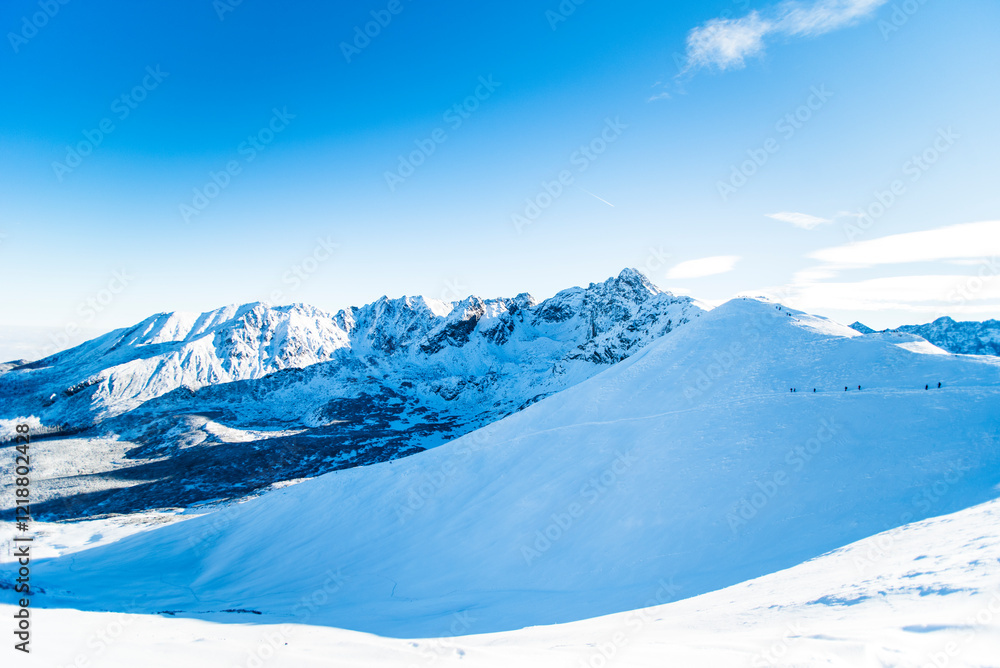 Obraz premium Tatra mountains at winter time. View of the white snow-capped peaks, frosty winter mountains. Kasprowy Wierch, High Tatra, Poland, Europe.