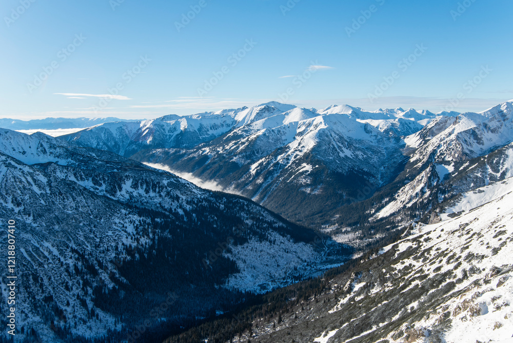 Fototapeta premium Tatra mountains at winter time. View of the white snow-capped peaks, frosty winter mountains. Kasprowy Wierch, High Tatra, Poland, Europe.