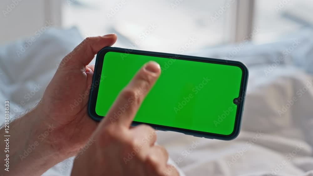 Man hand scrolling mockup cellphone in bed choosing purchases at morning closeup
