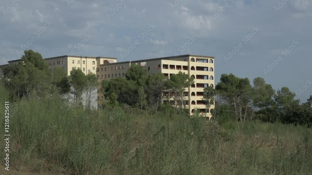 Old hospital restored as Parc Audiovisual, Terrassa, back long pines rear sun Old hospital restored as Parc Audiovisual, Terrassa, back long pines rear sun