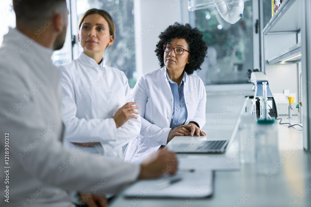 Group of scientists communicating in laboratory. Group of scientists communicating in laboratory.