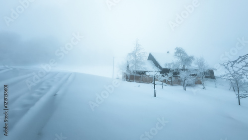 Mountain wooden house in winter scenery and fog in a dreamy mood photo