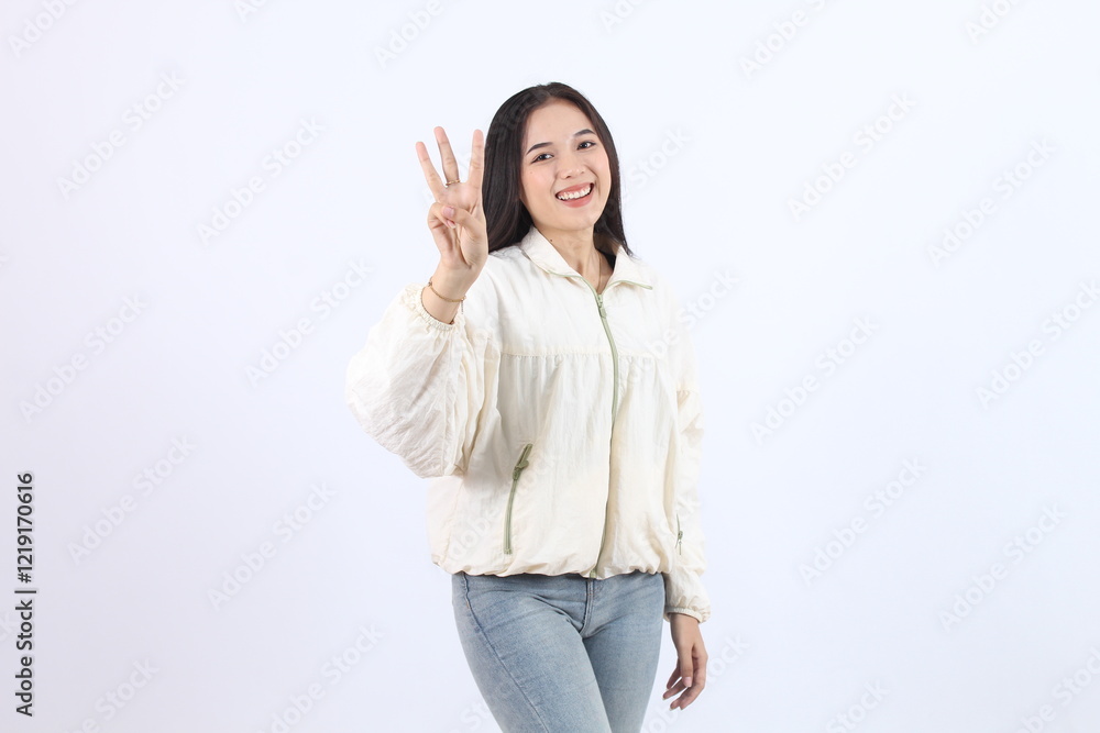 Smiling Adult Asian Woman Showing Peace Gesture in Casual Outfit showing number 3 (three) with finger Smiling Adult Asian Woman Showing Peace Gesture in Casual Outfit showing number 3 (three) with finger