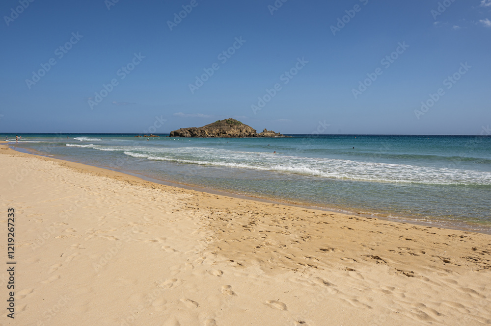 The beautiful beach of Su Giudeu in the south of Sardinia with transparent and turquoise water and a small island in front of the bay