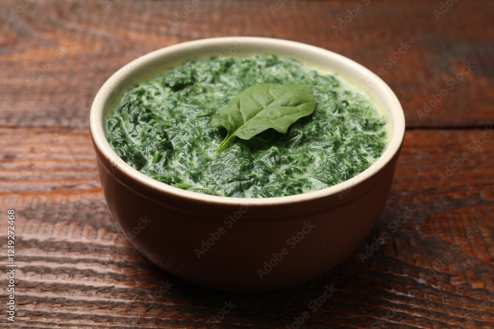 Delicious spinach sauce in bowl on wooden table, closeup Delicious spinach sauce in bowl on wooden table, closeup