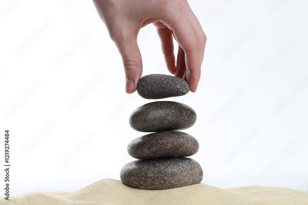 Woman making stack of stones on white background, closeup. Harmony and life balance Woman making stack of stones on white background, closeup. Harmony and life balance