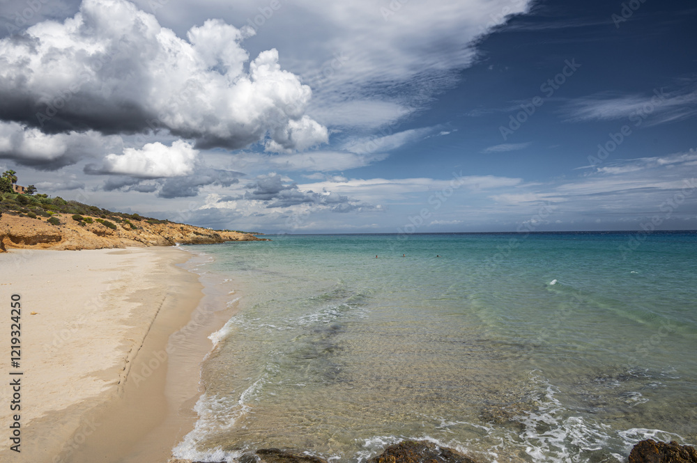 The beautiful beach of Pinus with fine sand and blue and turquoise water and storm clouds on the horizon