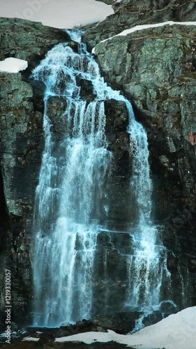 Aurlandsfjellet, Norway. Waterfall Flotvatnet In Spring Snowy Landscape. Road Aurlandsfjellet. Scenic Route Road In Summer Norwegian Landscape. Natural Norwegian Landmark And Popular Destination photo