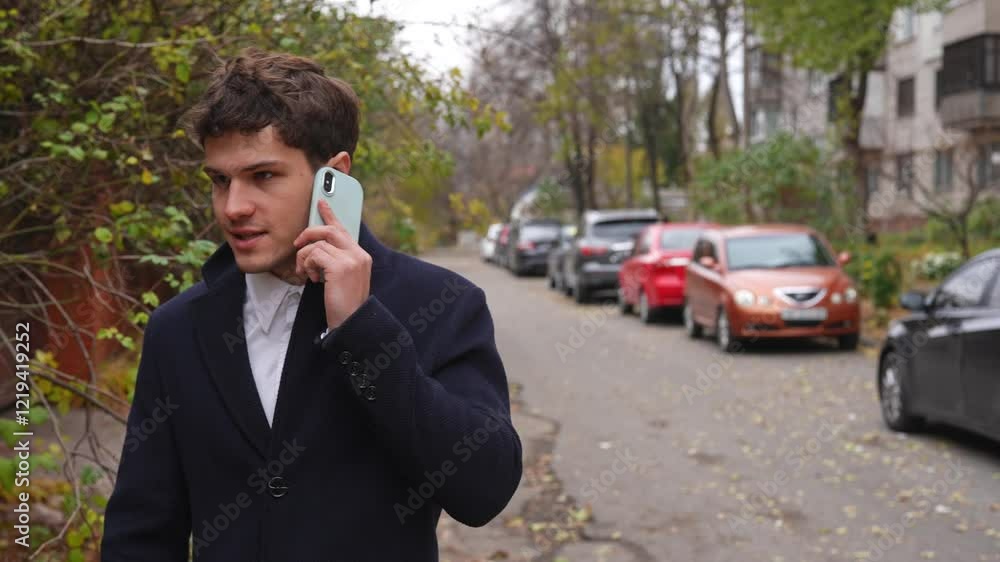 Young businessman in the morning enjoying his daily walk to the office in the city, walking on the street with briefcase and talking on smartphone. Young businessman in the morning enjoying his daily walk to the office in the city, walking on the street with briefcase and talking on smartphone.